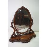 Large Victorian Mahogany Oval Swing Dressing Mirror held on a carved scrolling support and shaped