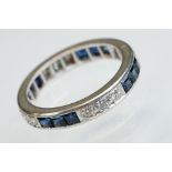 Diamond and sapphire white metal eternity ring, a total of twelve round brilliant cut diamonds, pavé