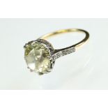 Pale yellow diamond unmarked yellow gold and platinum set ring, the cushion cut diamond weighing