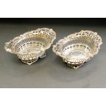 Pair of silver bon bon dishes, cherub mask heads, pierced foliate body, raised on four feet,