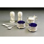 Silver cruet set comprising two open salt cellars, two pepper pots, a drum mustard pot and three