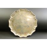 Silver salver raised on four scroll ball feet, pie crust border, the centre engraved "Captain C.H.