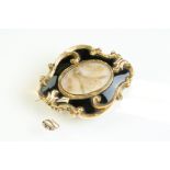 Early Victorian enamelled yellow metal mourning brooch, the glazed compartment to the centre with