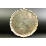 Silver salver raised on three feet, gadrooned border, cast stylised shell and foliate scroll