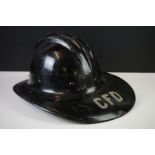 A vintage hard boiled fibreglass fireman's helmet, painted black and marked CFD (Chicago Fire