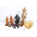 A collection of oriental carved wooden figures together with a lampshade in the form of a lily.