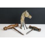 Two antique wooden handled corkscrews together with a bottle opener in the form of a horse.