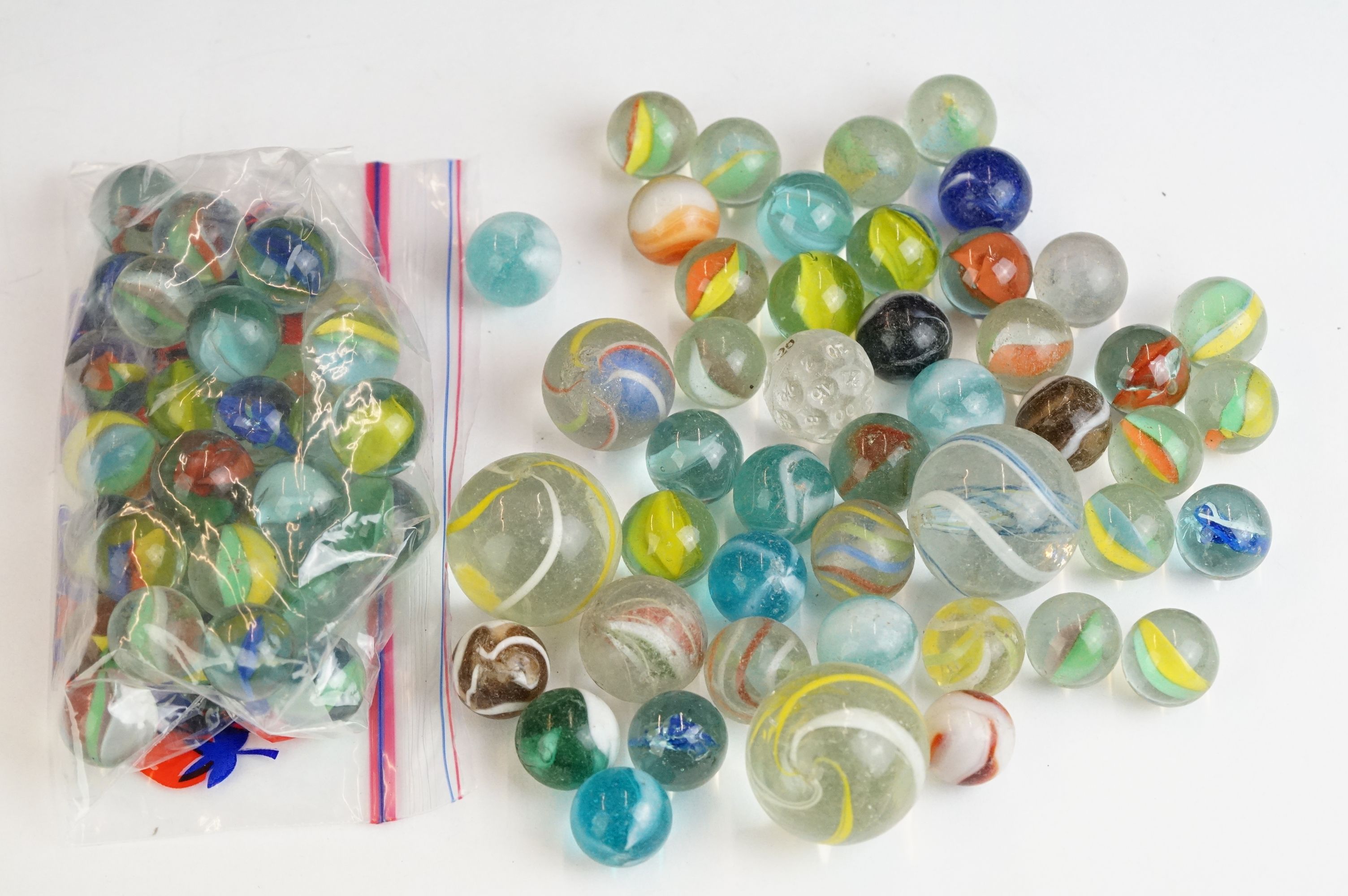 A small collection of vintage glass marbles contained within two bags.