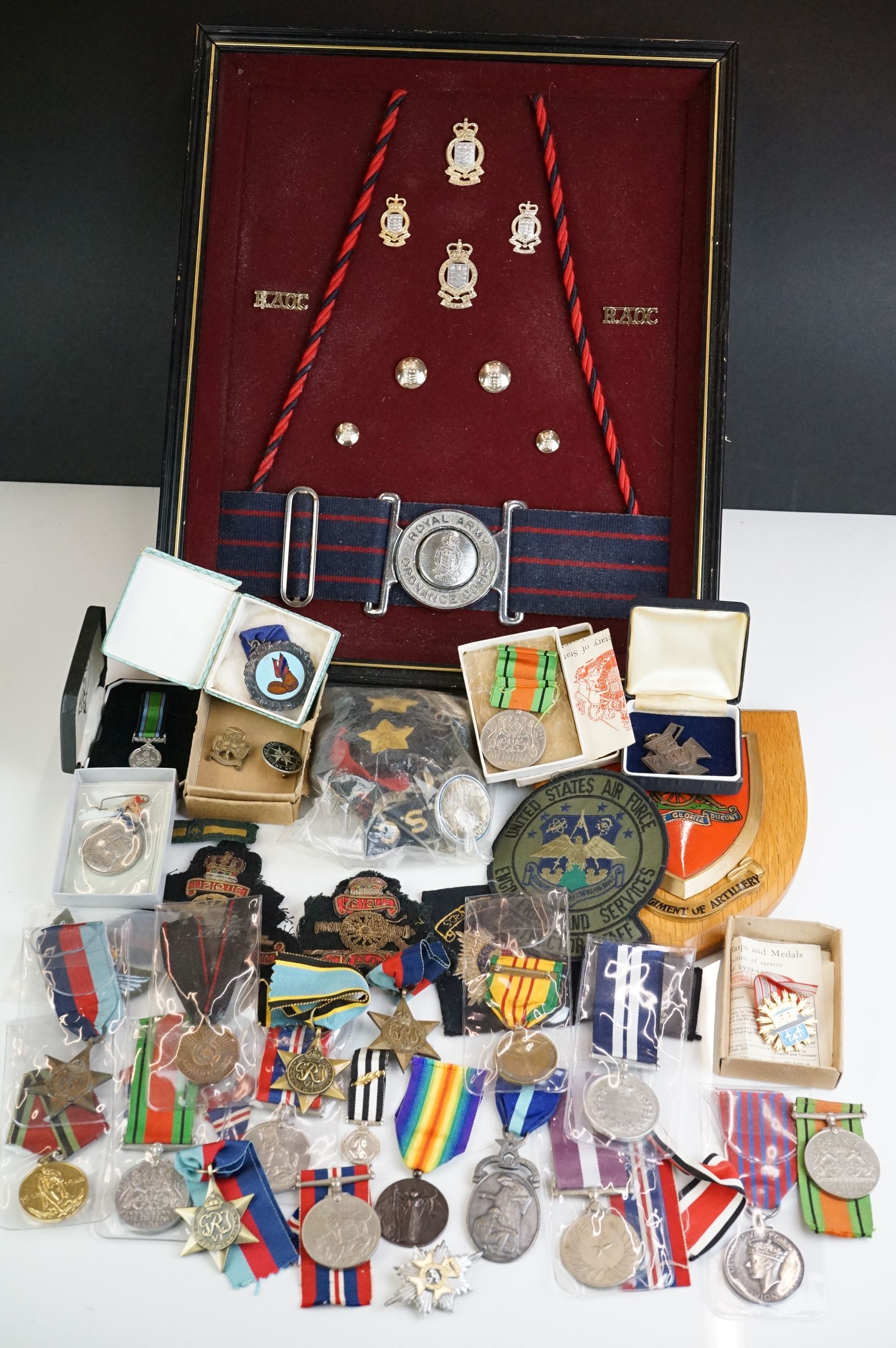 A group of military collectables to include a framed set of Royal Army Ordnance corps badges, a