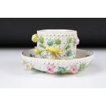 Meissen flower encrusted tumbler cup, applied with canaries, on a circular saucer, chipped to