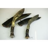 Two vintage Indian Kukri knives, the smaller with brass trim and the large with white metal, both