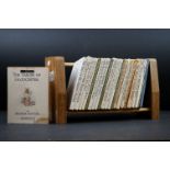 22 Beatrix Potter hard back books, varying ages, in a wooden display stand