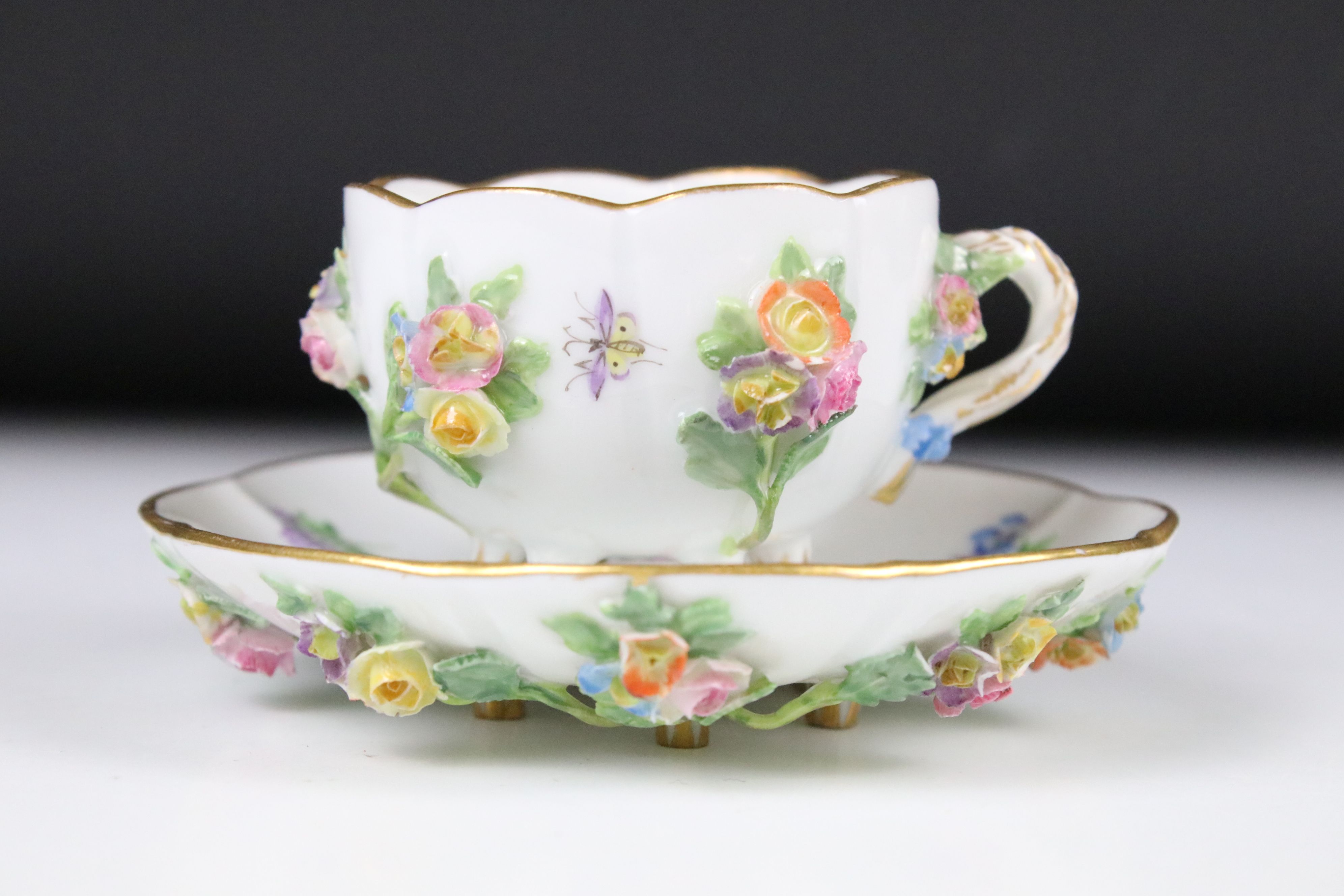 Meissen floral encrusted cup and saucer, decorated with insects and flowers