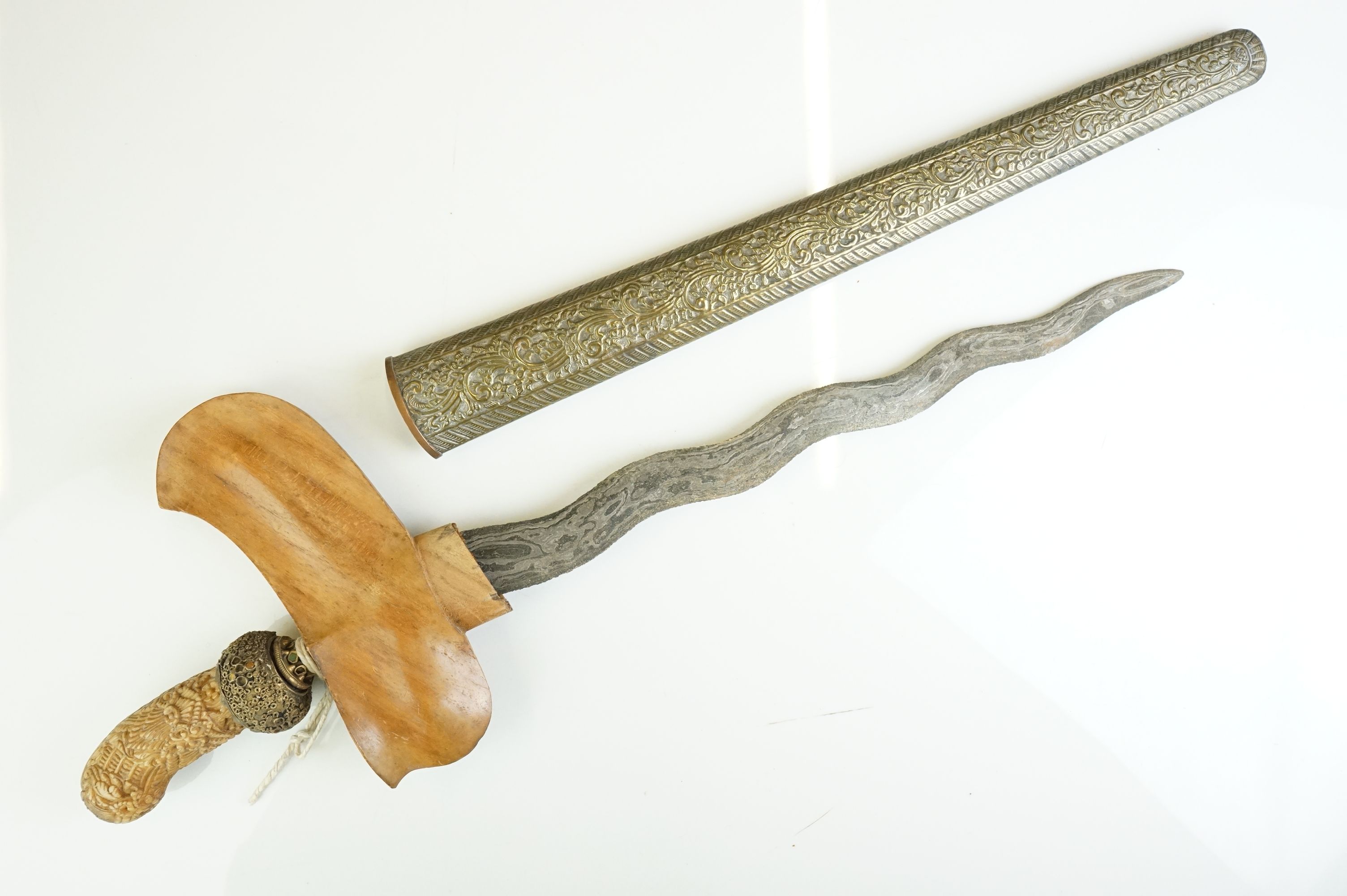 A 19th/20th Century Malaysian Kris Dagger with typical hand-forged wavy blade. It comes complete