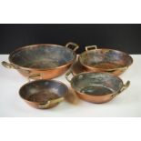 Set of Four Copper Graduating Circular Pans with twin brass handles, largest pan 23cm diameter