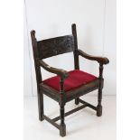 In the manner of Liberty of London, Gothic Revival Oak Elbow Chair with carved back rail and