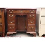 George III style Mahogany Kneehole Desk with an arrangement of seven drawers and central cupboard to