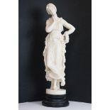 Resin sculpture of a classical maiden, in a pensive pose, raised on a wooden pedestal base. Measures
