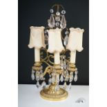 A gilt metal three branch table lamp with glass droplet decoration.