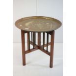 Brass Circular Tray Top Table raised on an oak folding base, 58cm wide x 51cm high