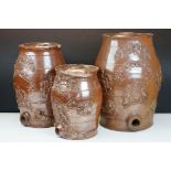 Set of three graduating 19th century brown salt glazed stoneware spirit barrels, decorated in relief