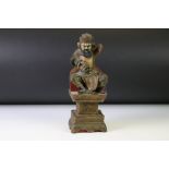 East Asian carved wooden sculpture of a figure seated upon a pedestal, with a dragon in one hand.