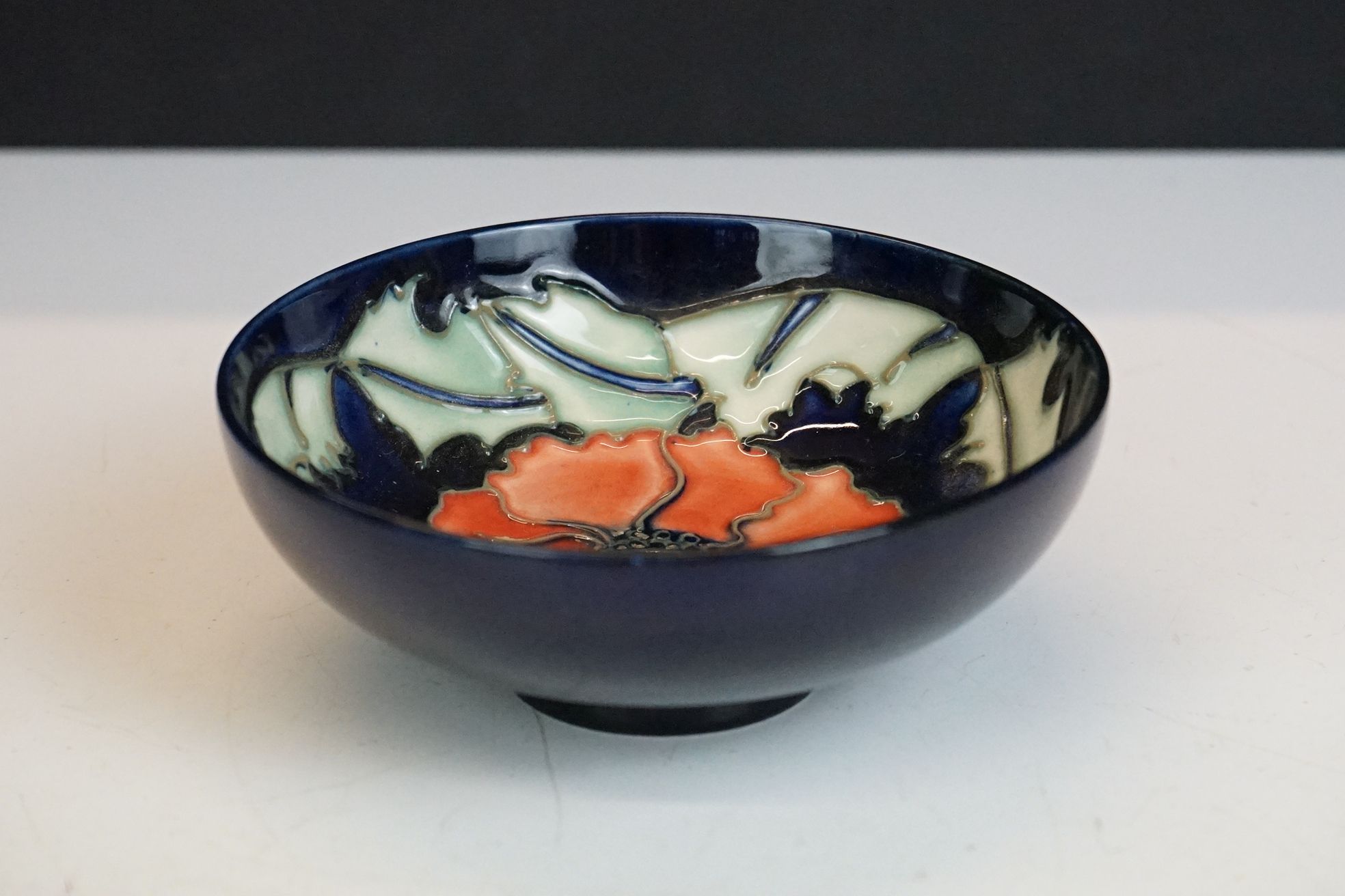 Moorcroft ' Poppy ' pattern small blue ground bowl / trinket dish, dated '96, 11.5cm diameter