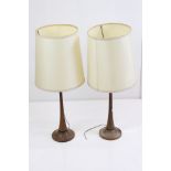 Pair of 1970's Scandinavian teak table lamps of tapering form, with pale yellow shades. Measure