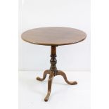 George III Mahogany Circular Tilt Top Supper Table raised on a turned pedestal with three outswept