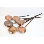 A collection of six antique copper bed warming pans.