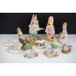 Twelve pottery and porcelain figures to include, a pair of porcelain figures of sheep modelled