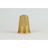 A vintage yellow metal thimble with engraved cartouche.