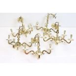 A group of five contemporary brass three branch chandeliers.