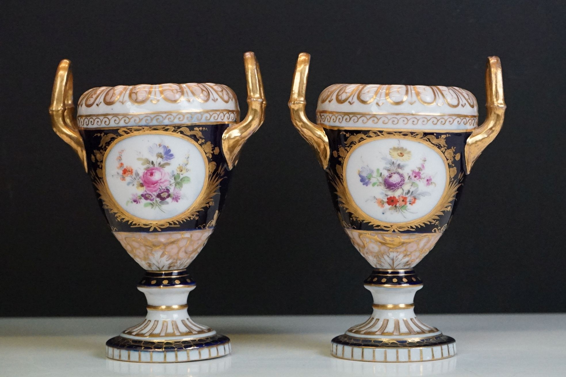 Pair of late 19th / early 20th century Continental porcelain twin-handled urn vases, with hand