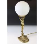 Art deco style brass table lamp modelled as a nude lady holding a globe aloft, with opaque white