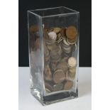 A collection of British pre decimal coins contained within a glass vase.