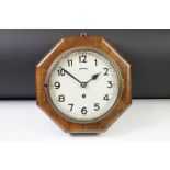 Art Deco oak cased octagonal wall clock with cream dial, Arabic numerals and poker hands. Measures