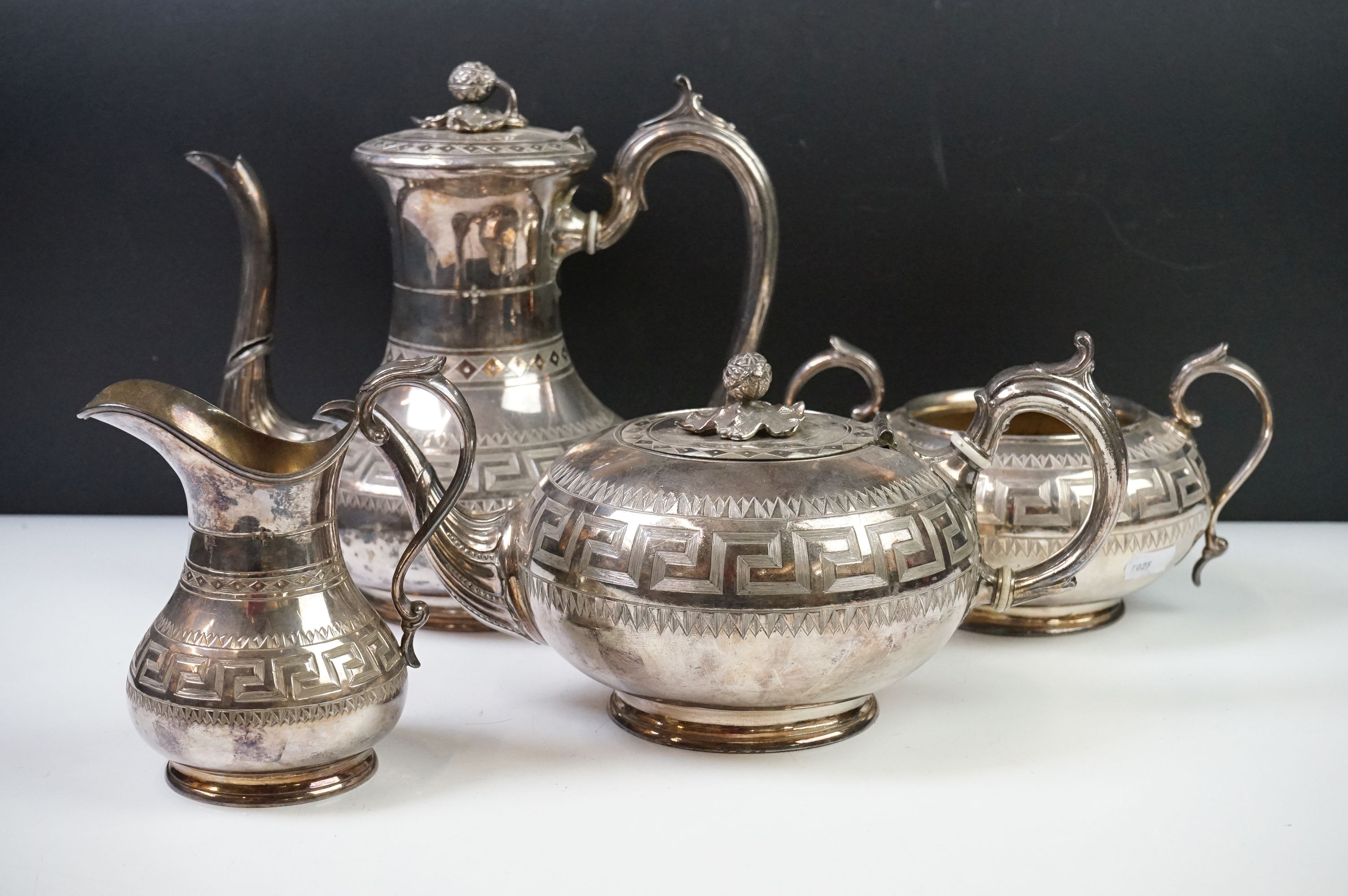 An antique silver plated tea set to include teapot, cream jug, sugar bowl and water jug decorated