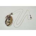 Large silver pendant photo locket in the form of an owl with ruby eyes