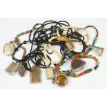 A collection of assorted Thai amulets on necklaces.