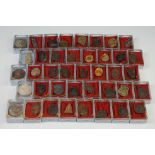 A collection of 40 Thai budhist amulets contained within individual boxes.