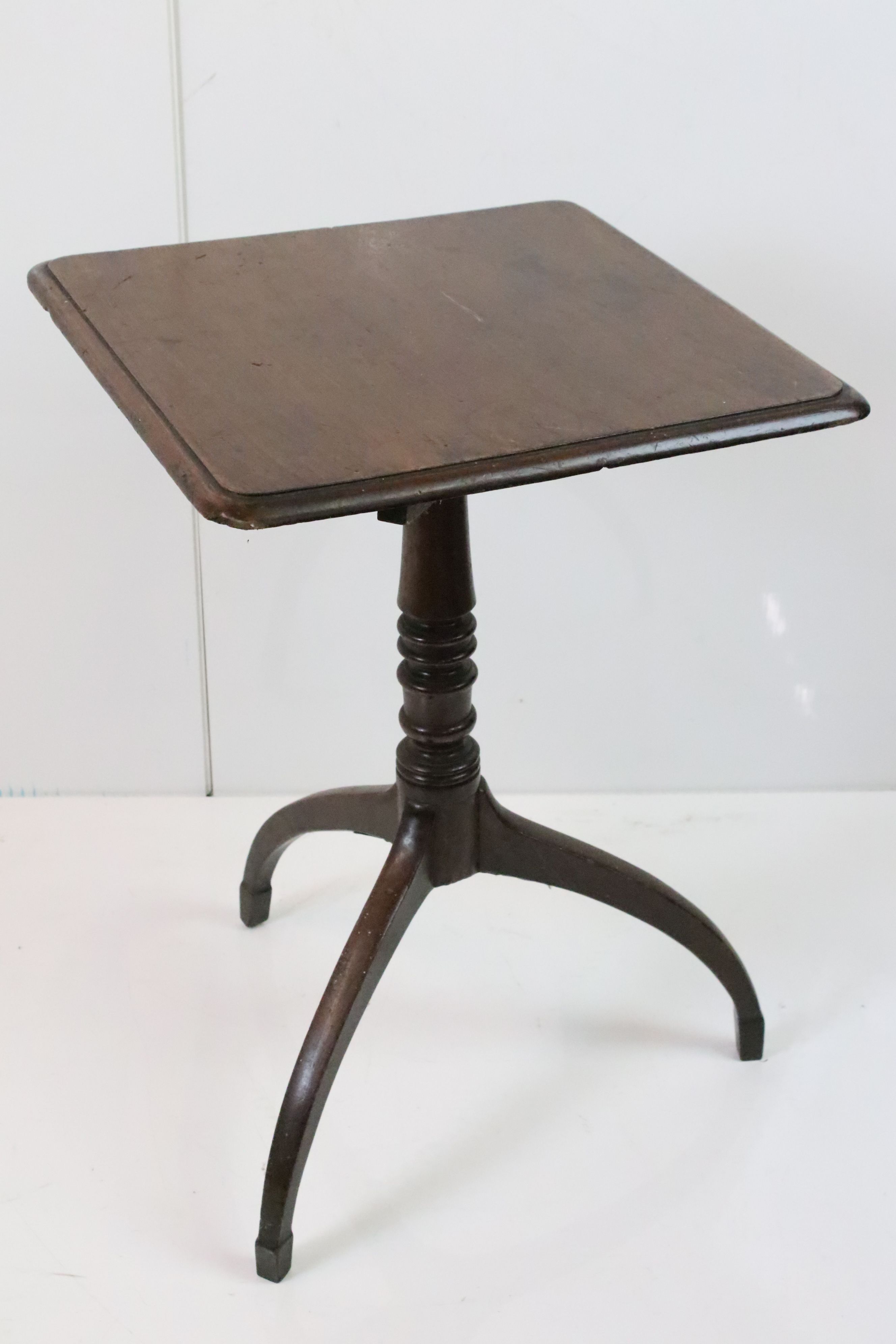George III Mahogany Square Tilt Top Table, raised on a turned pedestal with three down swept legs,