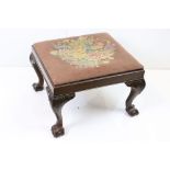 George II style carved mahogany stool, the rectangular needlepoint drop in seat on leaf carved