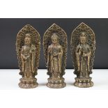 A group of three bronze statues of Chinese gods, all with character marks to bases.