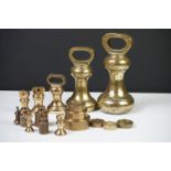 A collection of brass weights of various shapes and sizes.