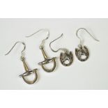 Two pairs of silver drop earrings, one horseshoe shaped, the other stirrup shaped