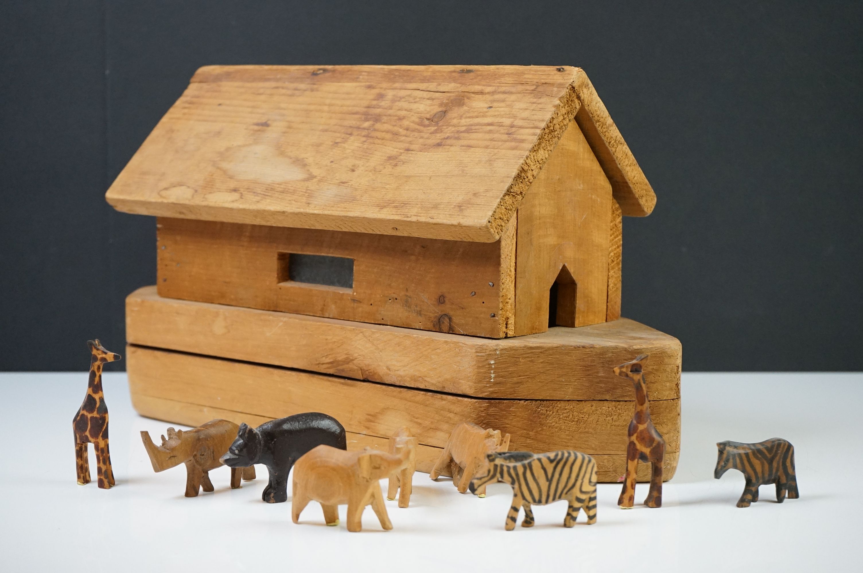 Wooden Noah's Ark model with nine carved animals (giraffes, elephants, etc). Ark measures approx