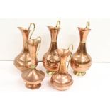 A collection of five large copper jugs / vases with brass fittings.