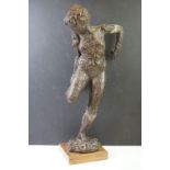 Plaster sculpture of a nude female checking the sole of one foot, textured finish, raised on a