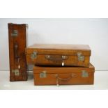 A collection of three brown leather covered suitcases to include a Harrods example